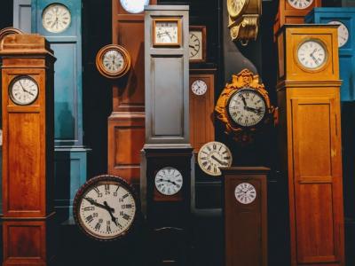 A room full of tall clocks in varying colors.