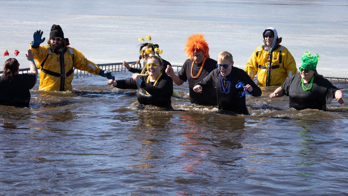A group of people in the water with colorful decorations.